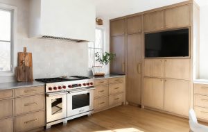 Custom slim shaker kitchen cabinets in a contemporary style kitchen featuring rift sawn white oak and painted perimeter casework