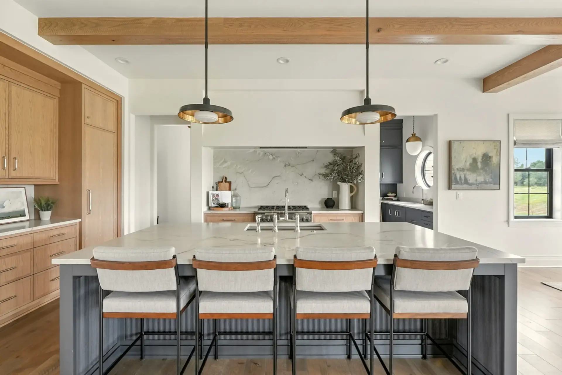 Close-up profile of a modern transitional kitchen featuring a fluted charcoal island, white quartz tops, and oak integrated appliance towers.