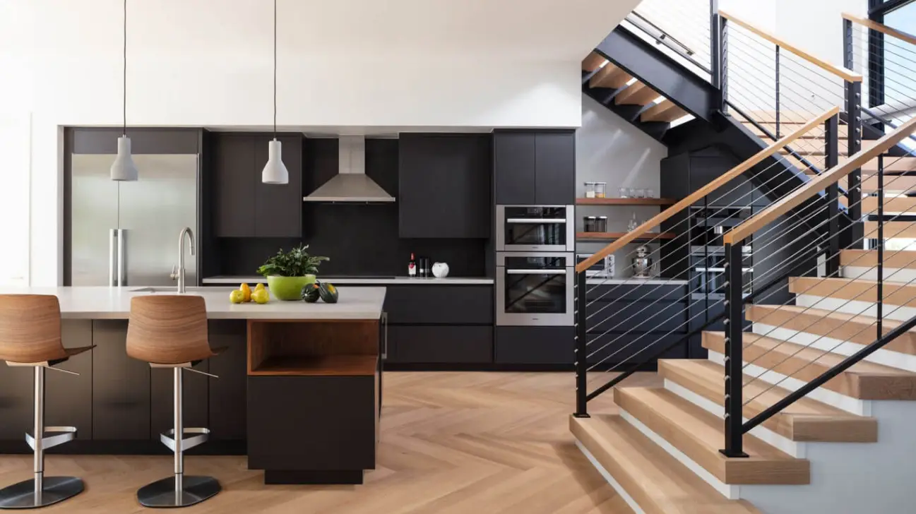 Modern matte black slab kitchen cabinets in a minimal open-concept home.