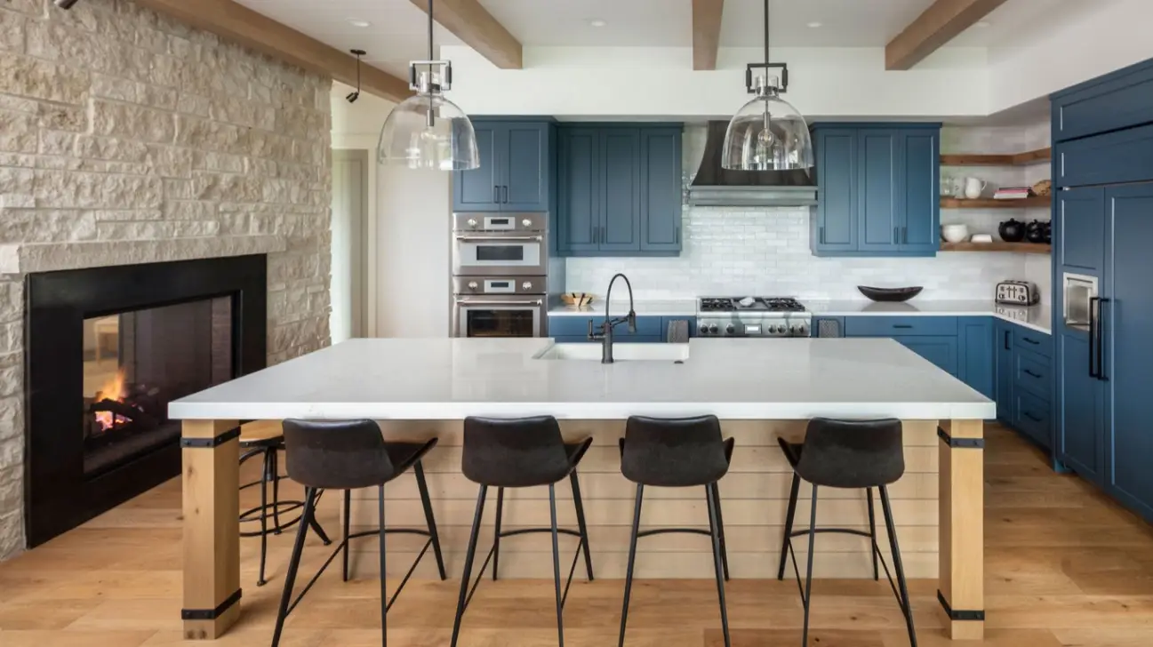 Deep navy blue shaker kitchen cabinets with light wood floors and white quartz island.