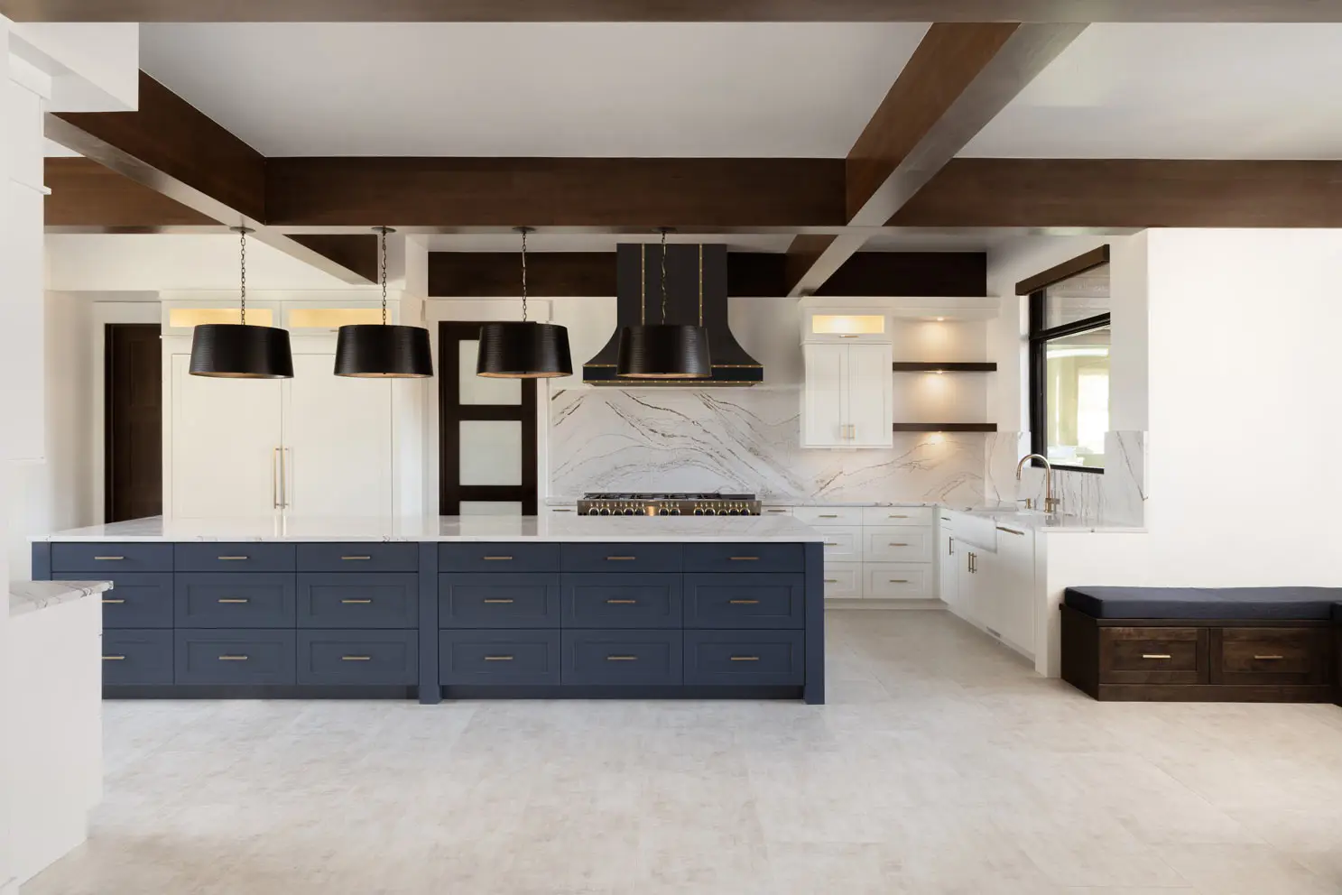 Luxury coastal kitchen featuring white lacquered shaker cabinets and an oversized navy blue kitchen island with premium white quartz countertops.