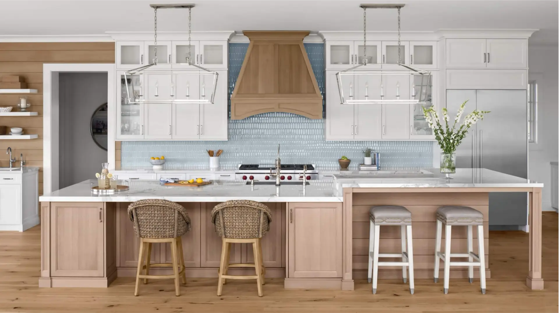 White shaker kitchen cabinets with a rift-sawn oak island and blue tile backsplash.