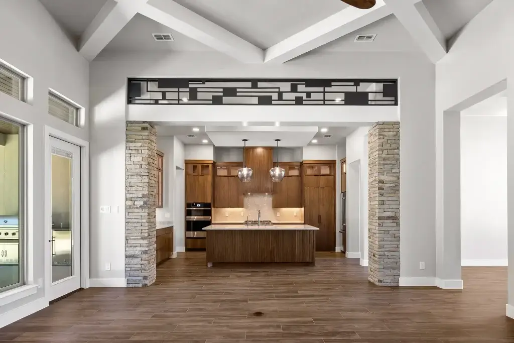 Contemporary open layout kitchen featuring integrated natural walnut kitchen cabinets, a fluted wood island, and a hidden pantry door in kitchen.