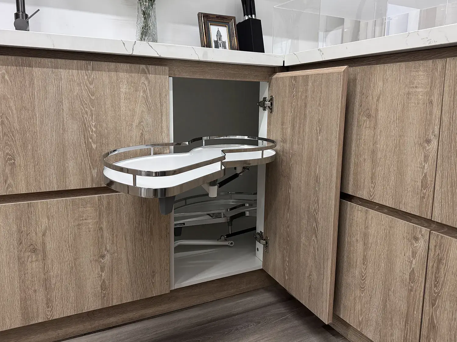etailed close-up of a custom white oak u shaped base corner cabinet featuring an extended Kessebohmer LeMans II swivel mechanism pull-out tray.