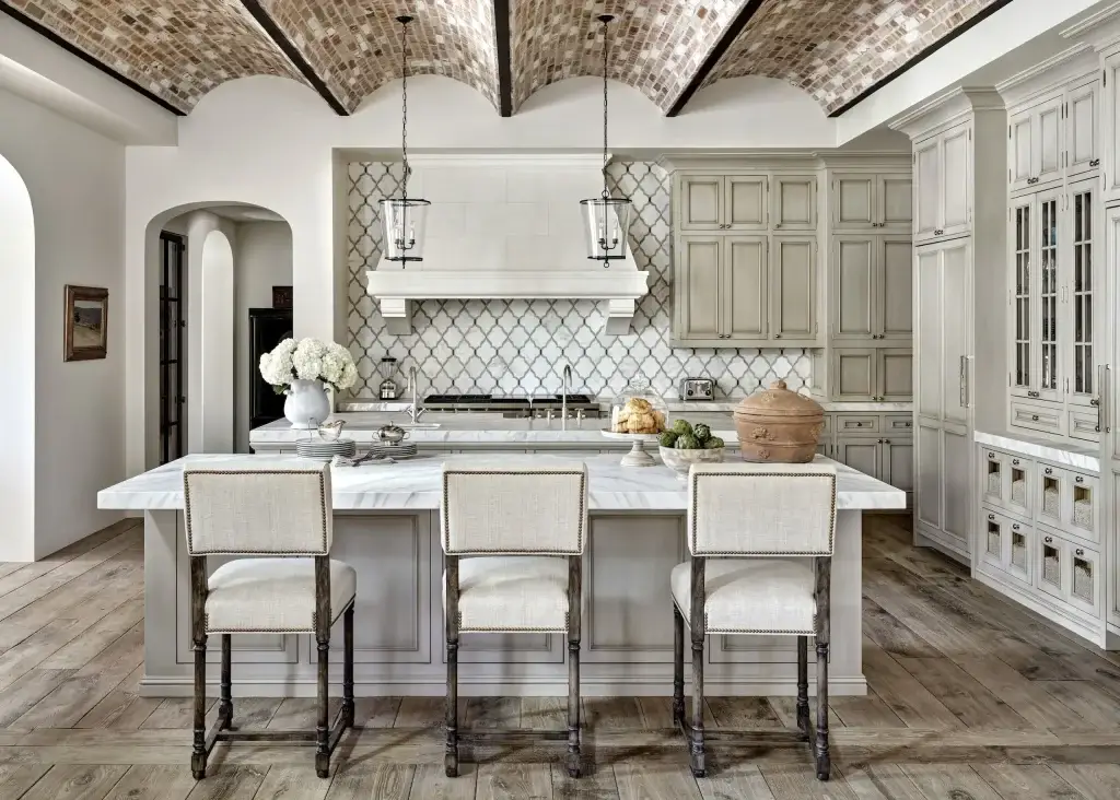 Wide spatial view of distressed kitchen cabinets featuring double preparation islands and brick vaulted ceilings.