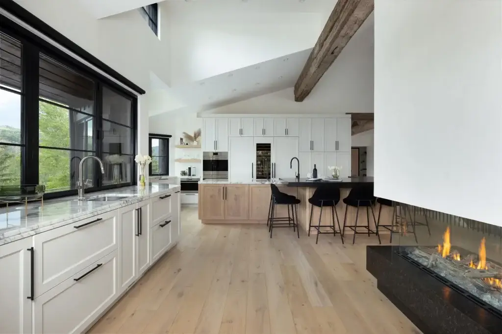 Side perspective of an optimized farmhouse country kitchen ideas plan transitioning smoothly into a living area with a linear gas fireplace.