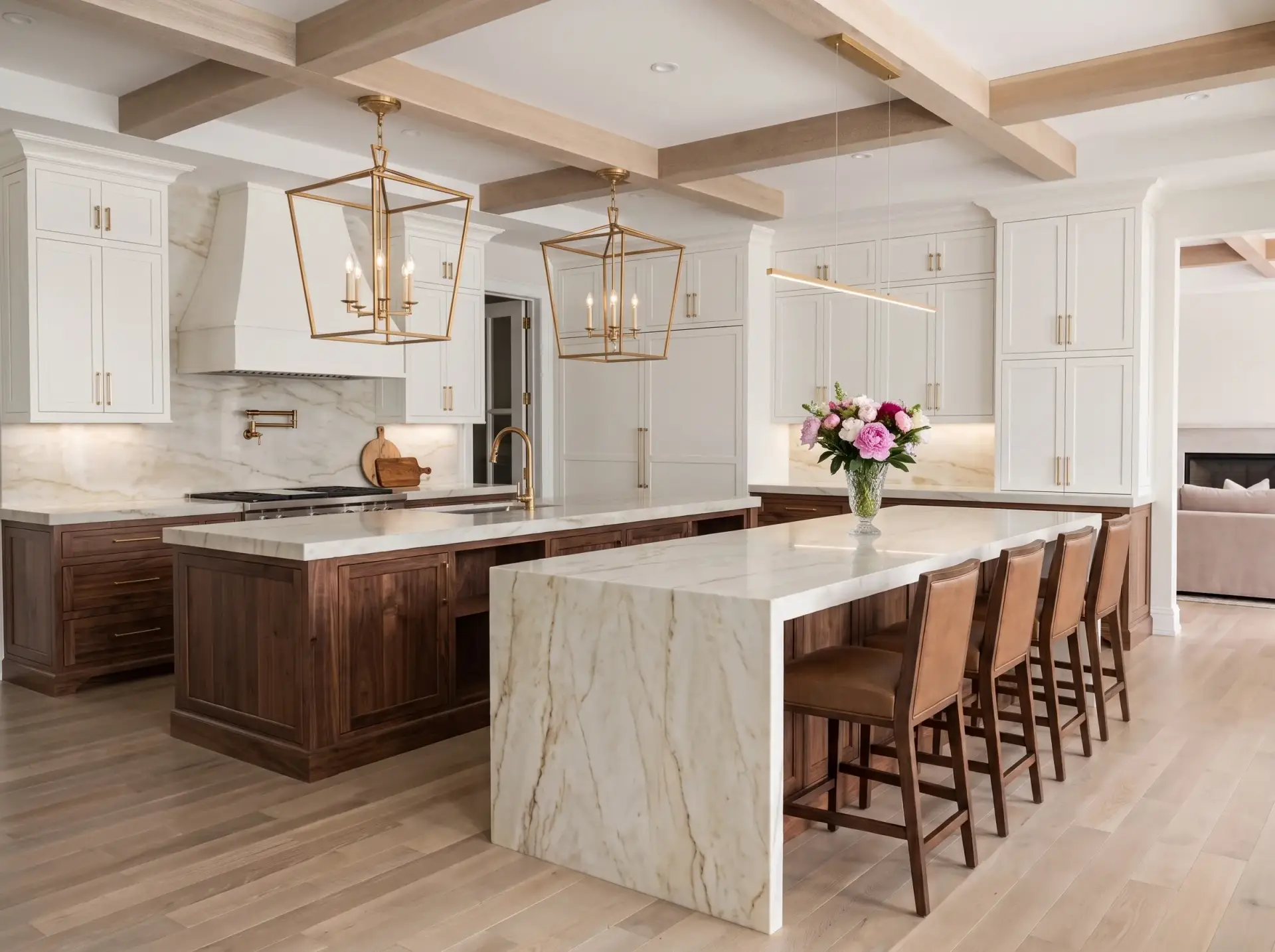 Luxury kitchen layout featuring a double-island configuration with custom walnut millwork and quartzite waterfall countertops facing an open living area.