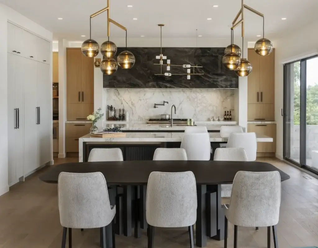 Wide spatial view of a custom two tone kitchen wood and white featuring light oak pantry columns and an integrated dining table.
