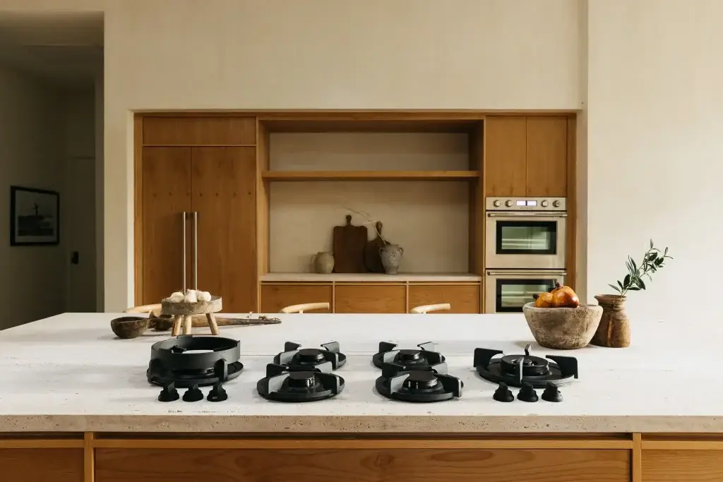 Center elevation of cherry wood kitchens featuring a panel-ready refrigerator wall, open shelves, and double ovens.
