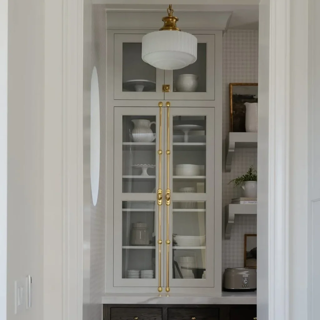 Upper kitchen cabinets featuring smoked glass cabinet doors set in ultra-slim matte black aluminum frames with warm interior LED shelf lighting.