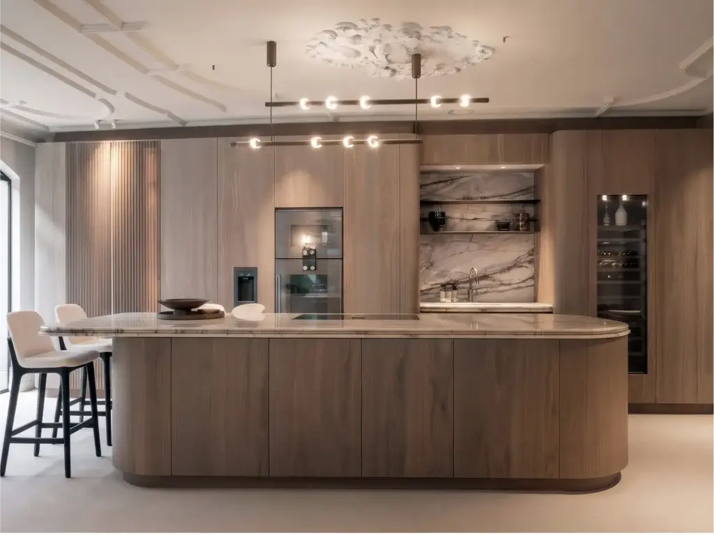 Luxury hidden kitchen with custom wood veneer tall cabinetry, integrated appliances, and a curved marble island