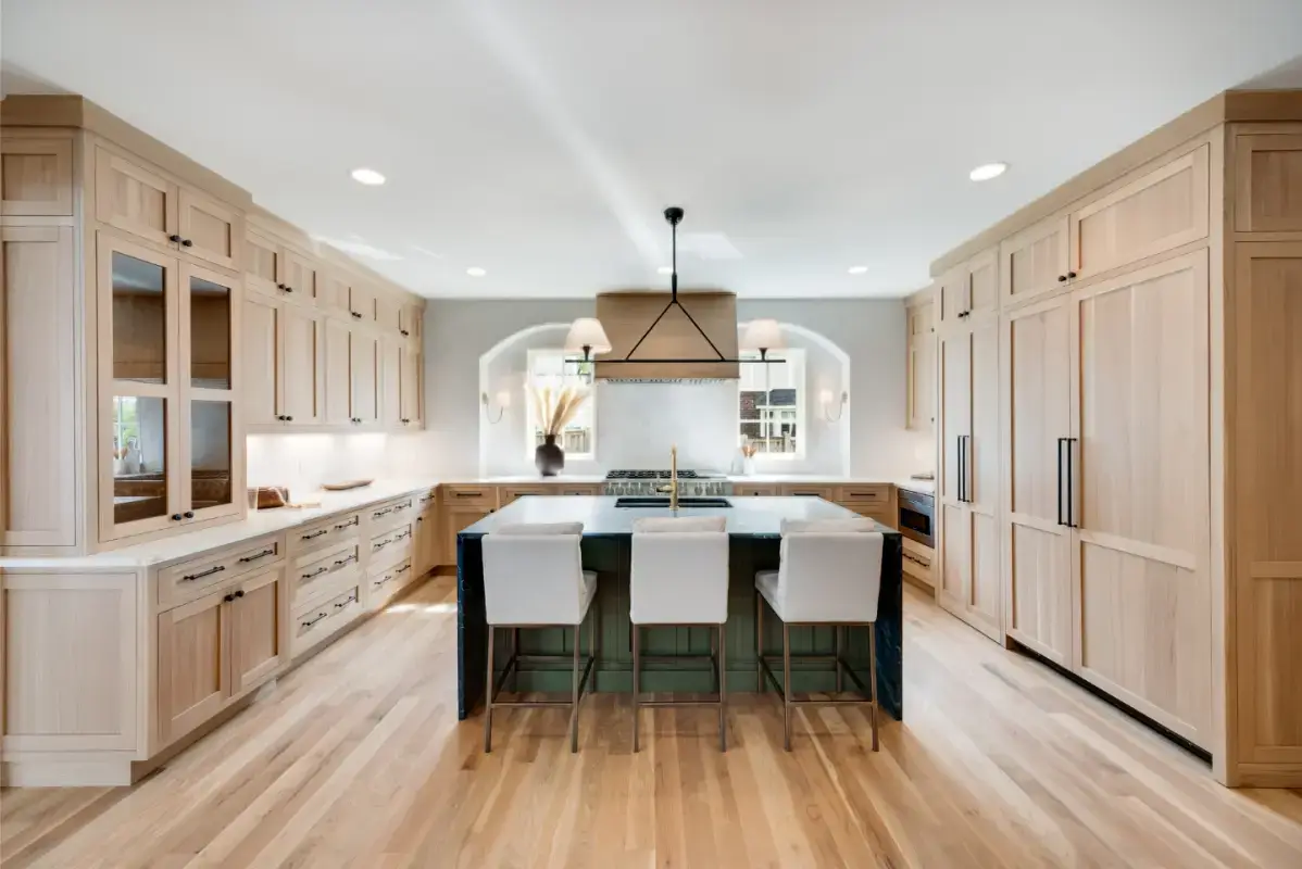 Luxury custom wood kitchen cabinets in rift-cut white oak featuring integrated tall pantry wall and waterfall island by ALLAND Custom Cabinetry