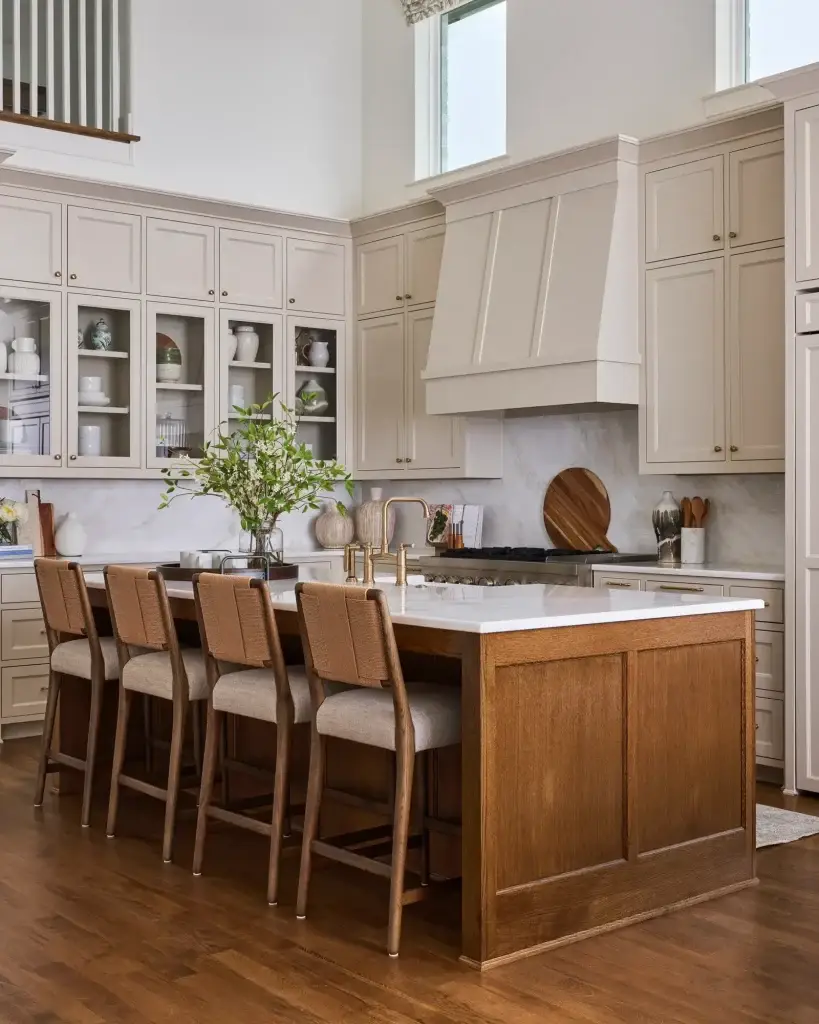 Side angle of modern european kitchen designs highlighting white oak island seating, glass display, and marble counters.