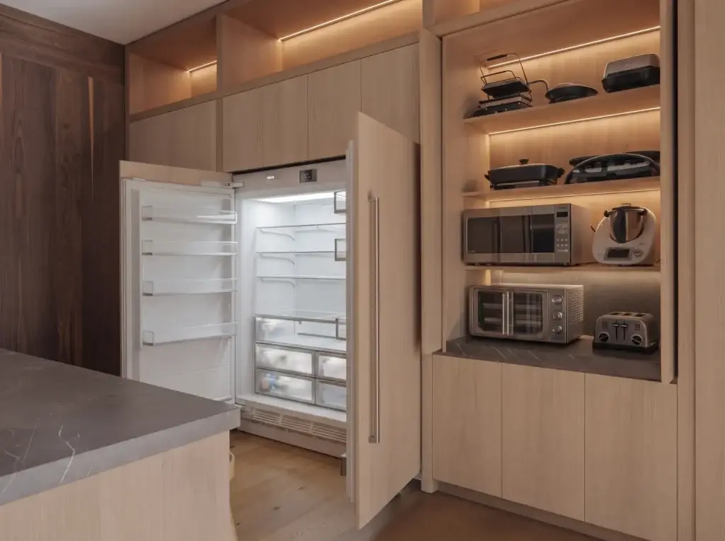 Panel-ready built-in refrigerator and kitchen cabinets with appliance garage featuring white oak slab doors in a modern luxury kitchen