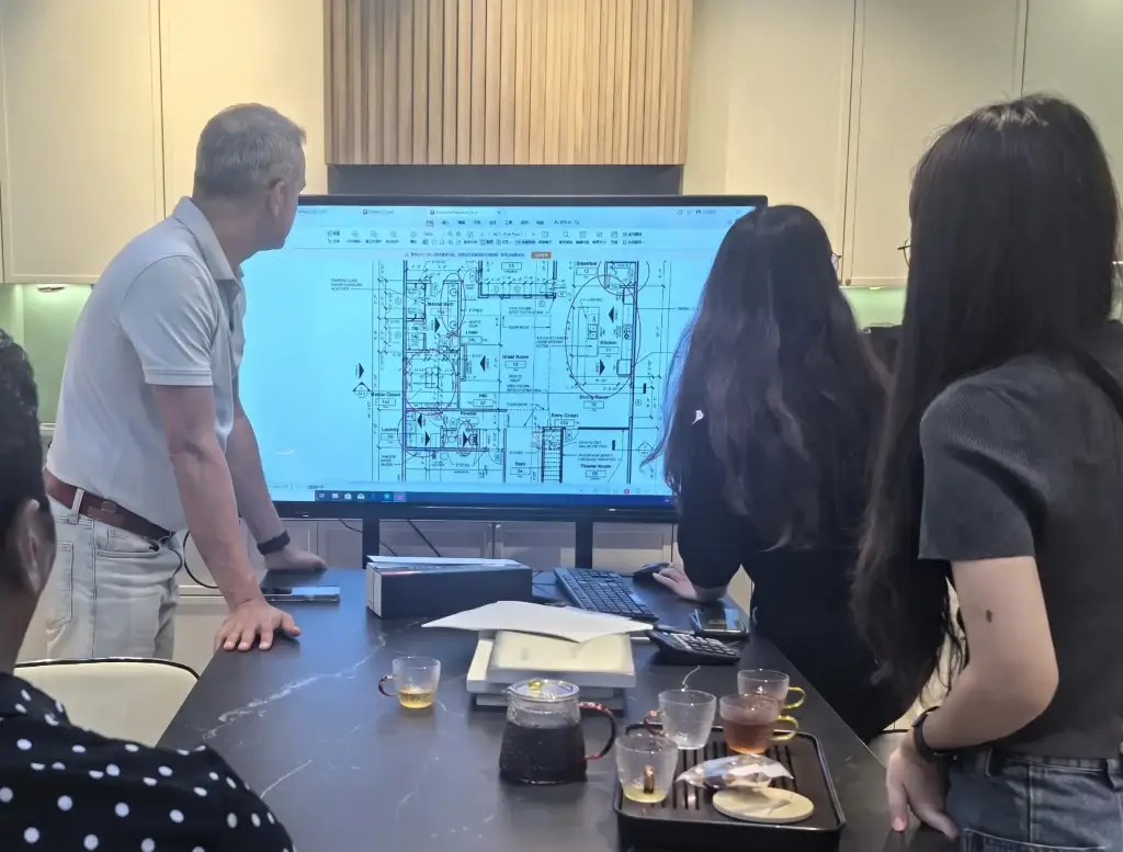 Engineering team reviewing architectural CAD plans with client for custom cabinets and millwork architect collaboration