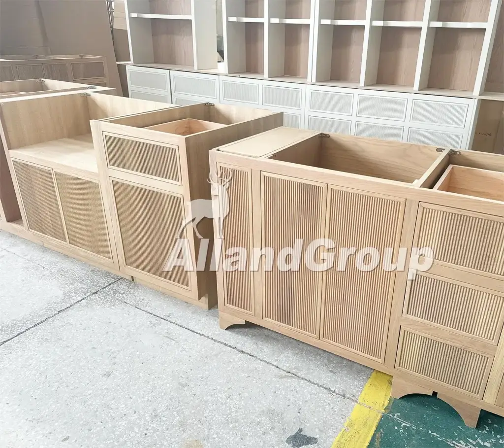 Factory floor pre-assembly run for fluted white oak cabinets and modular shelving