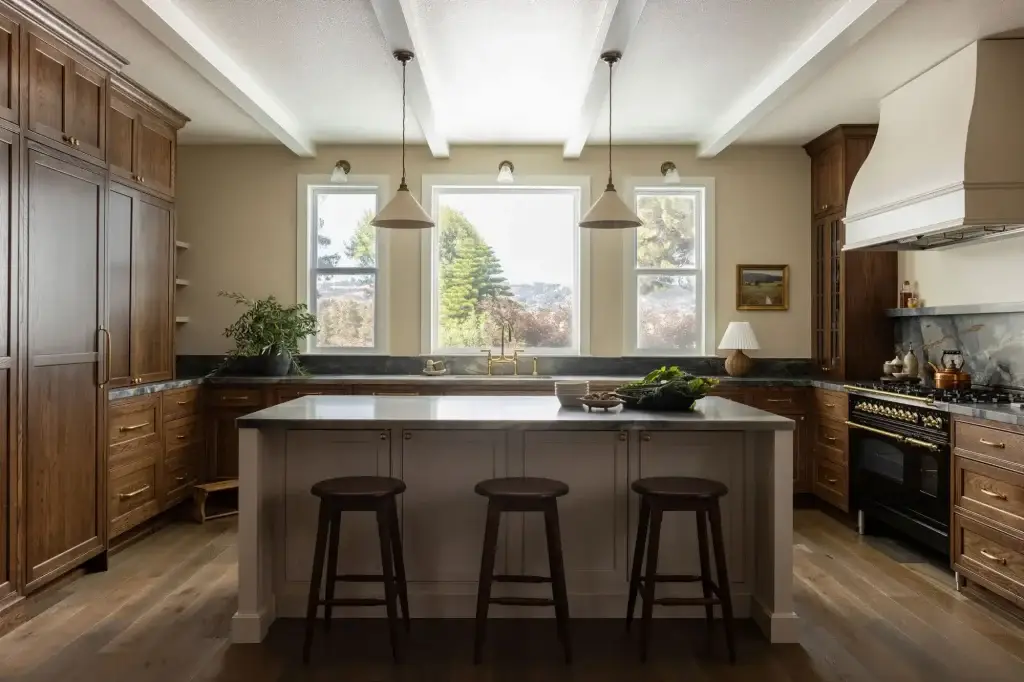 Full height custom walnut kitchen cabinets and statement wall paired with a contrasting warm white island