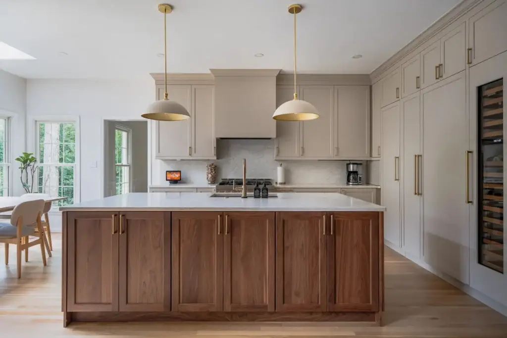 Modern two tone kitchen island different color from cabinets featuring warm white perimeter and dark walnut island