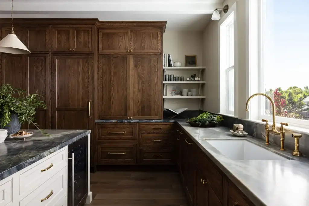 Floor-to-ceiling modern walnut kitchen cabinets with integrated panel-ready storage and contrasting white island