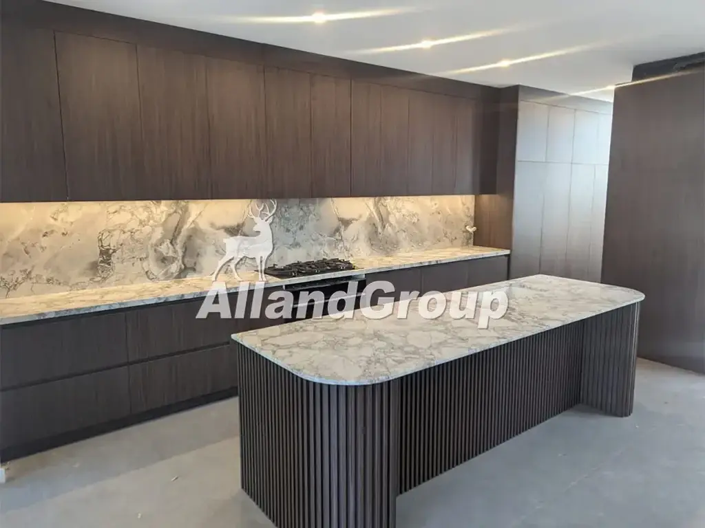 Modern dark wood veneer kitchen cabinets with curved island and waterfall countertop