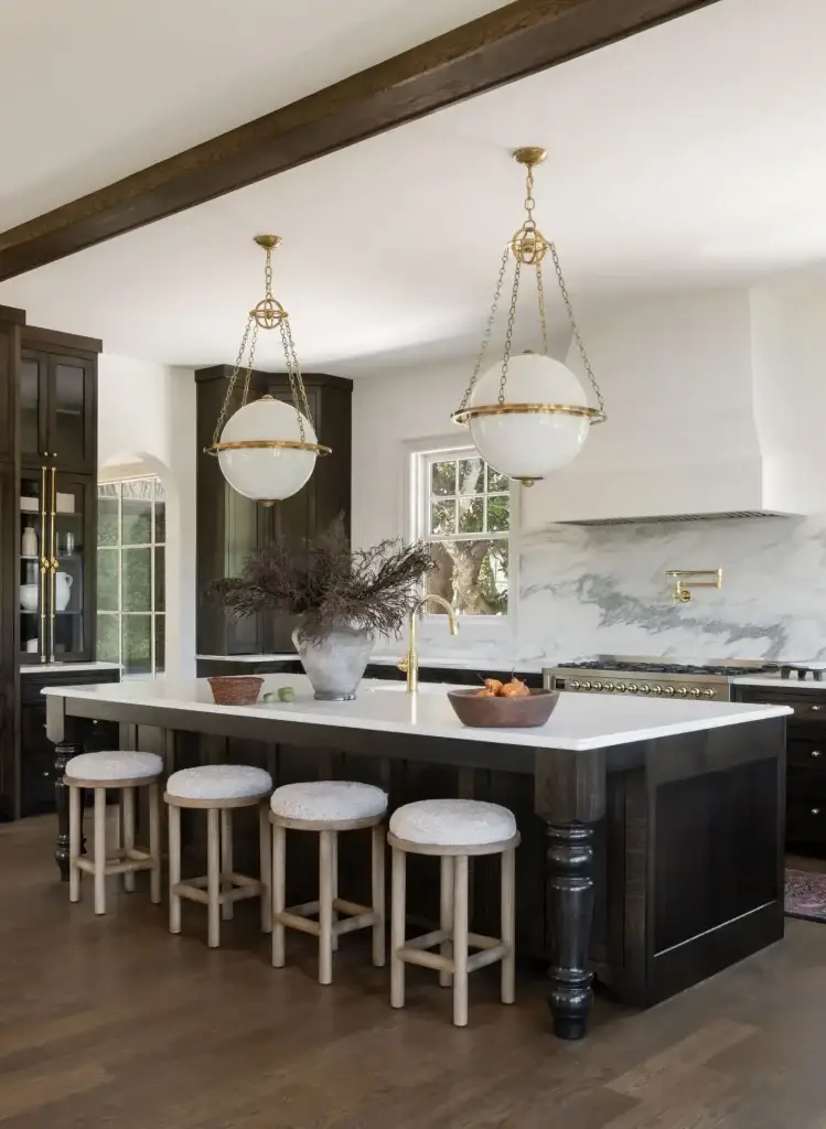 Contemporary dark wood kitchen cabinets island with marble countertops and brass globe pendants